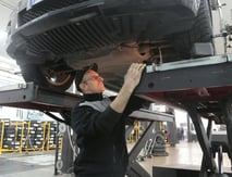 a man in a black shirt is working on a vehicle