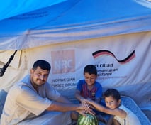 a man and two children sitting on a picnic table