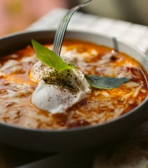 a bowl of soup with a fork and a fork