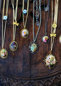 A selection of Elfin Forest’s best-selling botanical jewelry, featuring resin pendants and floral ri