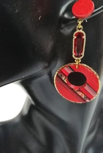 a woman's earring with a red and black earrings