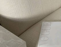 Soft neutral-toned fabric with a Vogue magazine, representing brand aesthetics and style.