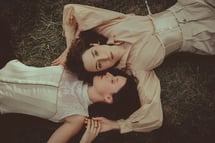 "Pareja lesbiana vista desde arriba, abrazándose en el suelo, celebrando el amor en una boda gay."