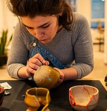 a woman is repairing ceramics with kintsugi reparatur 