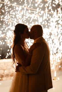 Magical stage fountain fireworks lighting up a Santorini wedding under the stars.