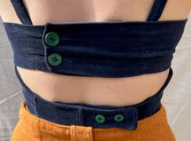 The back of a navy corduroy bustier fastened with green buttons