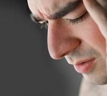 Homme souffrant, main sur le visage, soulager douleur chronique et fibromyalgie, avec l'hypnose.