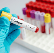 a person in gloves and gloves holding a tube with a blood test tube