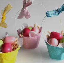 a group of three baskets with eggs and a bow tie