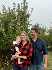 a man and woman standing in front of a tree