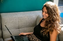 a woman sitting on a couch with a laptop