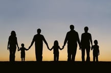 silhouette of an extended family walking along holding hands