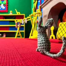 A crocheted gray mouse sits near the fireplace in Goodnight Moon by Dundee & Lee artists Emilie Odeile & Ken Chapin.