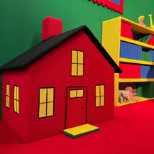 A knitted red and yellow dollhouse in Goodnight Moon - A Fiber Tale by Dundee & Lee artists Emilie Odeile & Ken Chapin.