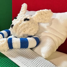 A knitted baby bunny in bed from Goodnight Moon - A Fiber Tale by Dundee & Lee artists Emilie Odeile & Ken Chapin.