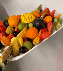 a platter of fruit and vegetables on a white plate