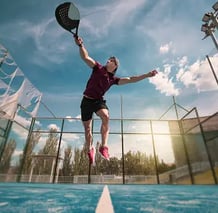 a man is jumping in the air with a tennis racket