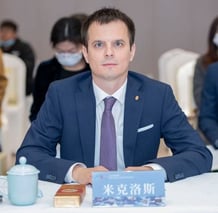 a man in a suit and tie sitting at a table