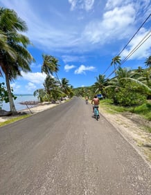 Cycling along a scenic blue route surrounded by lush greenery in Bora Bora, French Polynesia.