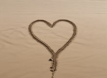 heart drawn on sand during daytime