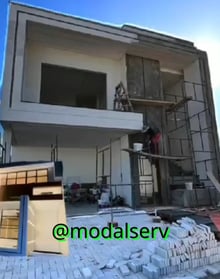 a man is standing on a scaffold of bricks