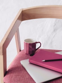 a cup and a notebook on a chair for personal work on reconnecting with yourself
