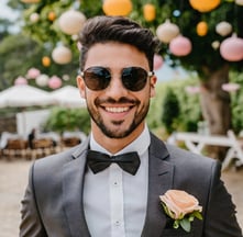 a groom in a suit and sunglasses smiling