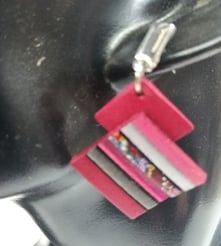 a woman's earring with a pink and white striped necklace