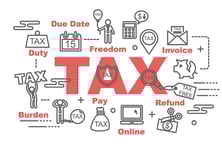 Tax documents and calculator arranged neatly on a table.