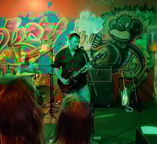 John onstage preforming with green background