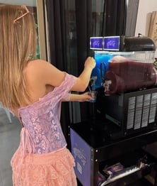 Liv pouring a cup of blue raspberry slushie from the SweetAz Co. slushie machine at her 16th birthday in Mount Cotton.