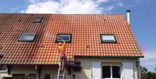 un homme qui traite une toiture