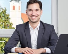 a man in a suit and tie smiling at the camera