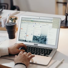 a person sitting at a desk with a laptop and trello