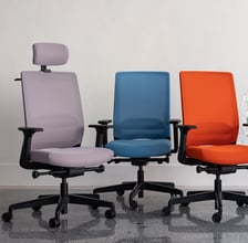 Three ergonomic office chairs in purple, blue, and orange on castors with armrests