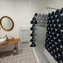 a bathroom with a shower and a wooden table