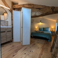 a bedroom with a bed and a wooden floor