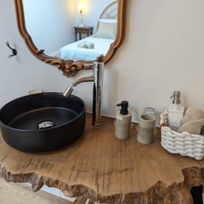 a bathroom sink with a wooden table and a mirror
