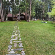 a stone path leading to a small cabin