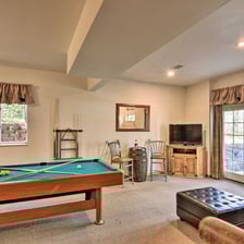 Alternate view of Moose Creek Lodge game room with pool table, TV, and bar seating.