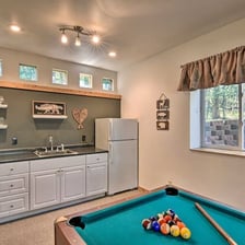 Basement kitchenette at Moose Creek Lodge with mini-fridge, sink, and pool table for entertainment.