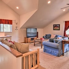 Comfy upstairs lounge with blue couches and a large TV.
