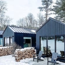 Tiny home pods with firewood stacks in snowy winter setting