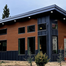 Modern tiny home pod with large windows and dark trim