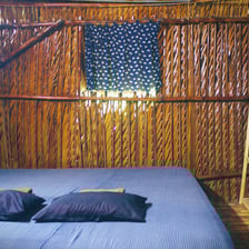 Cozy room with a comfortable sofa on the porch, perfect for relaxing in a rustic bamboo hut.