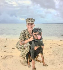a woman in uniform is holding a dog