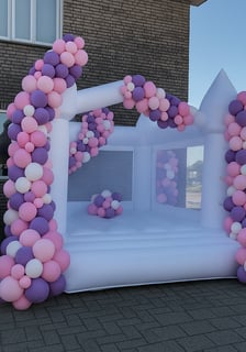 Wit springkussen met kleurrijke ballonnen, ideaal voor kinderfeestjes en evenementen.
