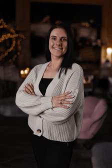 a woman in a white sweater and black pants