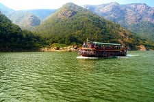 A boat with passengers travelling in mid of mountains