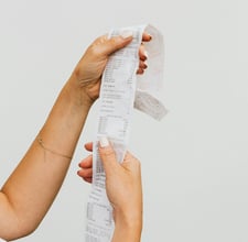 a woman holding a piece of paper with a receipt